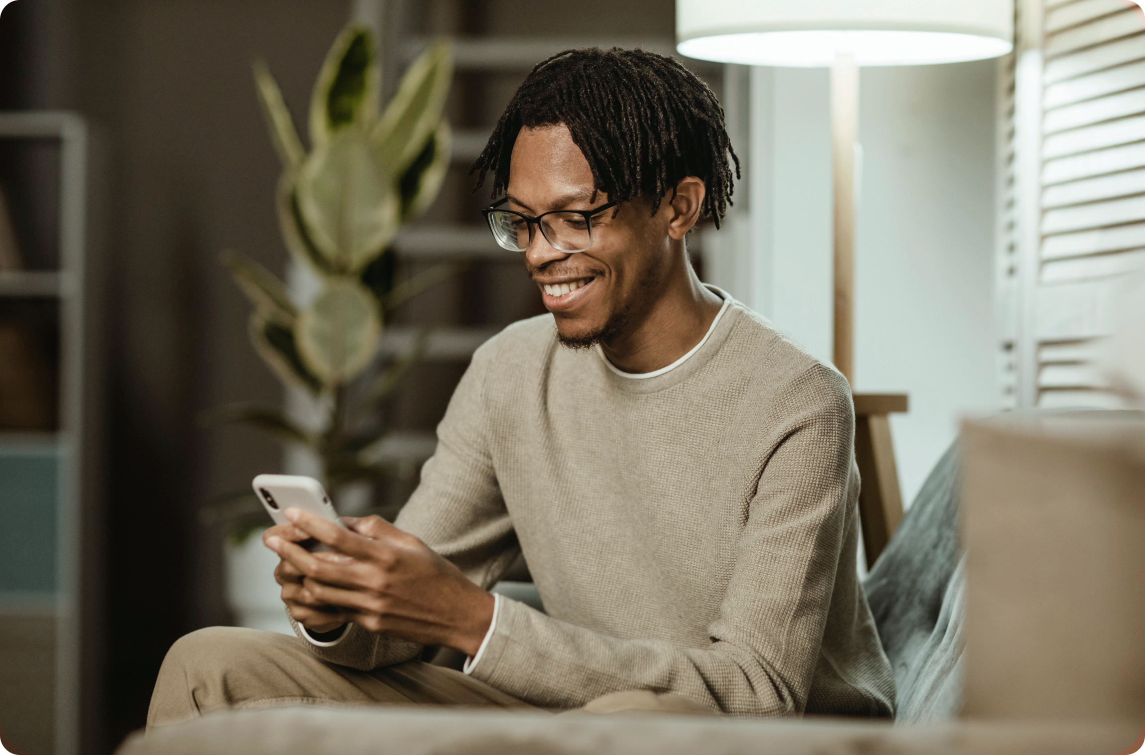 man using modern smartphone device while on couch at home